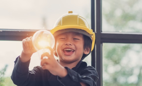 Smiling child holding a lightbulb
