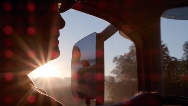Driver in a trailer cabin at sunset