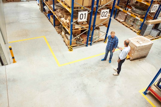 two men with parcels in a warehouse