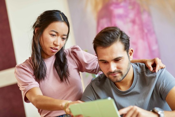 young man and woman using a tablet