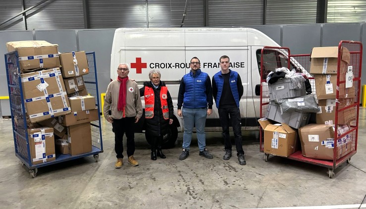 Remise solidaire de colis non identifiés par GLS à la Croix-Rouge française, avec des bénévoles de GLS et de la Croix-Rouge aux côtés des colis prêts à être distribués.