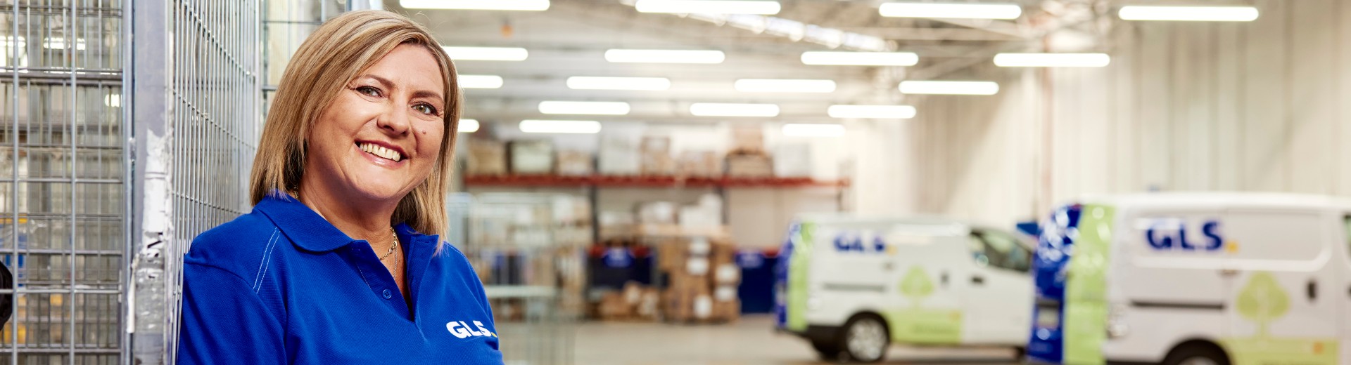  A GLS woman stands smiling in a GLS depot