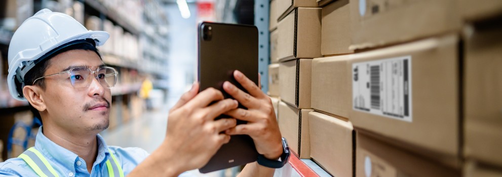 Man looking at his phone in a warehouse