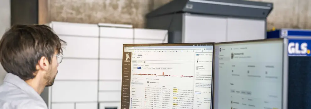 A man working on a computer with lines of code on the screen.